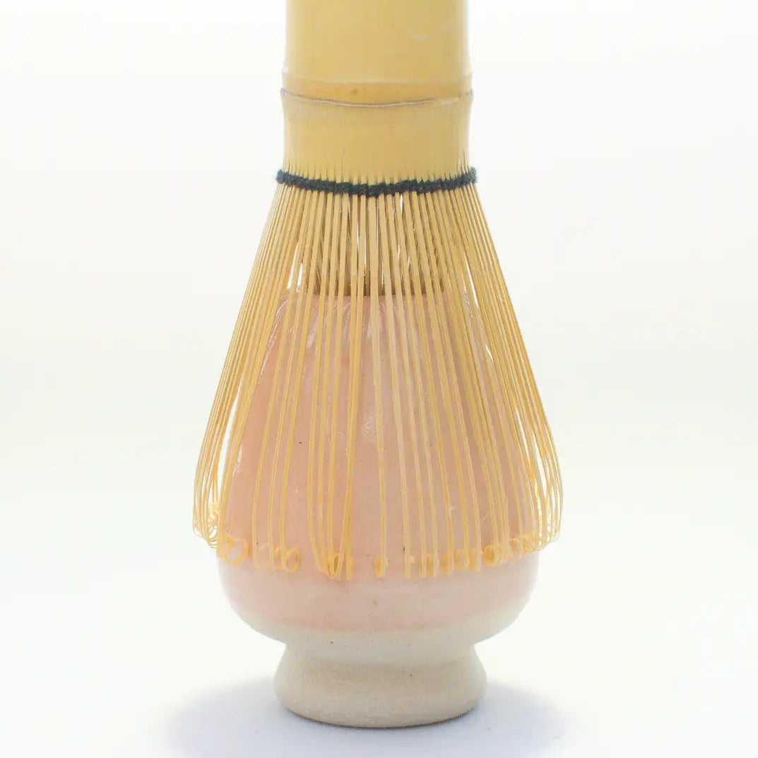Bamboo whisk with ceramic base on a white background