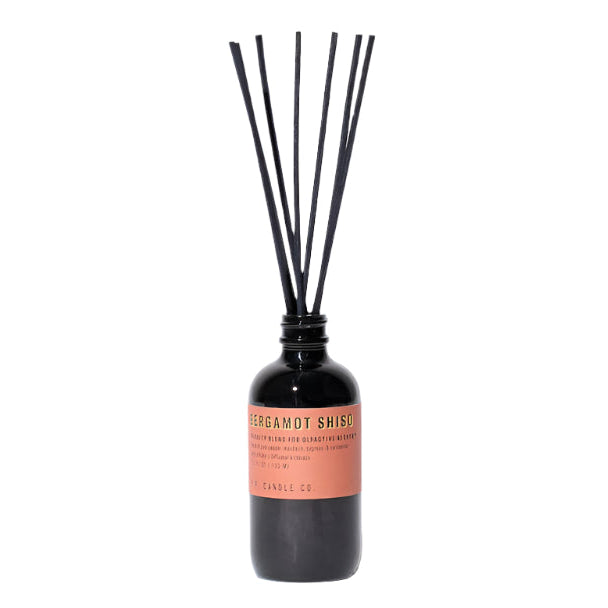 A reed diffuser with a smoke grey bottle and black dyed rattan reeds, labeled 'Bergamot Shiso'.