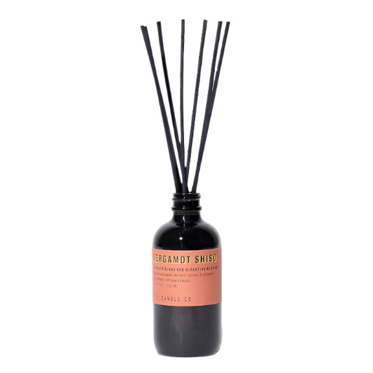 A reed diffuser with a smoke grey bottle and black dyed rattan reeds, labeled 'Bergamot Shiso'.
