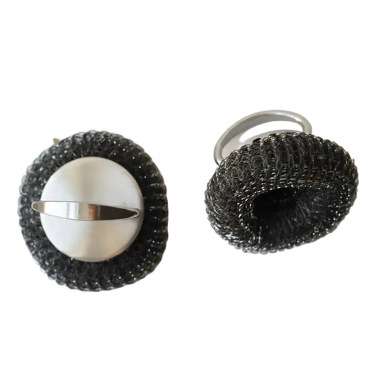 Two metal scrubbers with wire mesh on a white surface